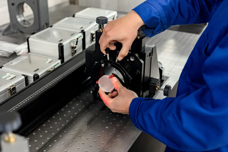 Engineer aligning an optical assembly on a bench